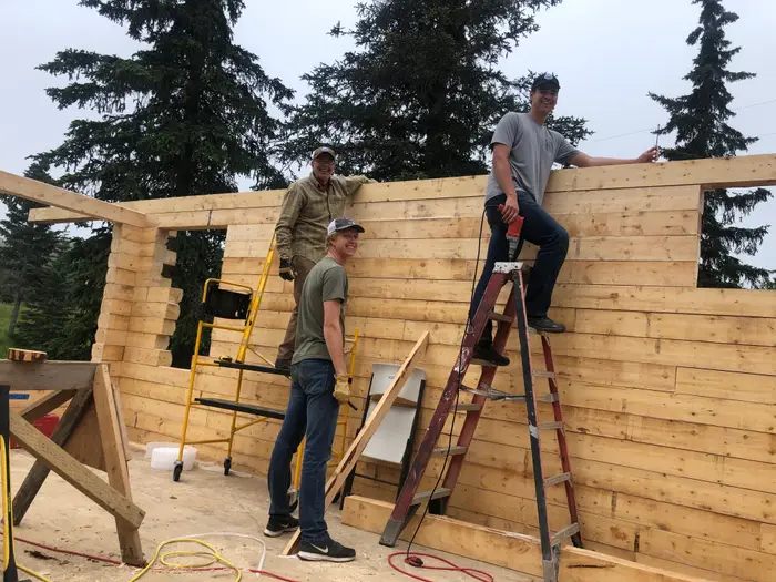 Hands on the frame, walls rising board by board