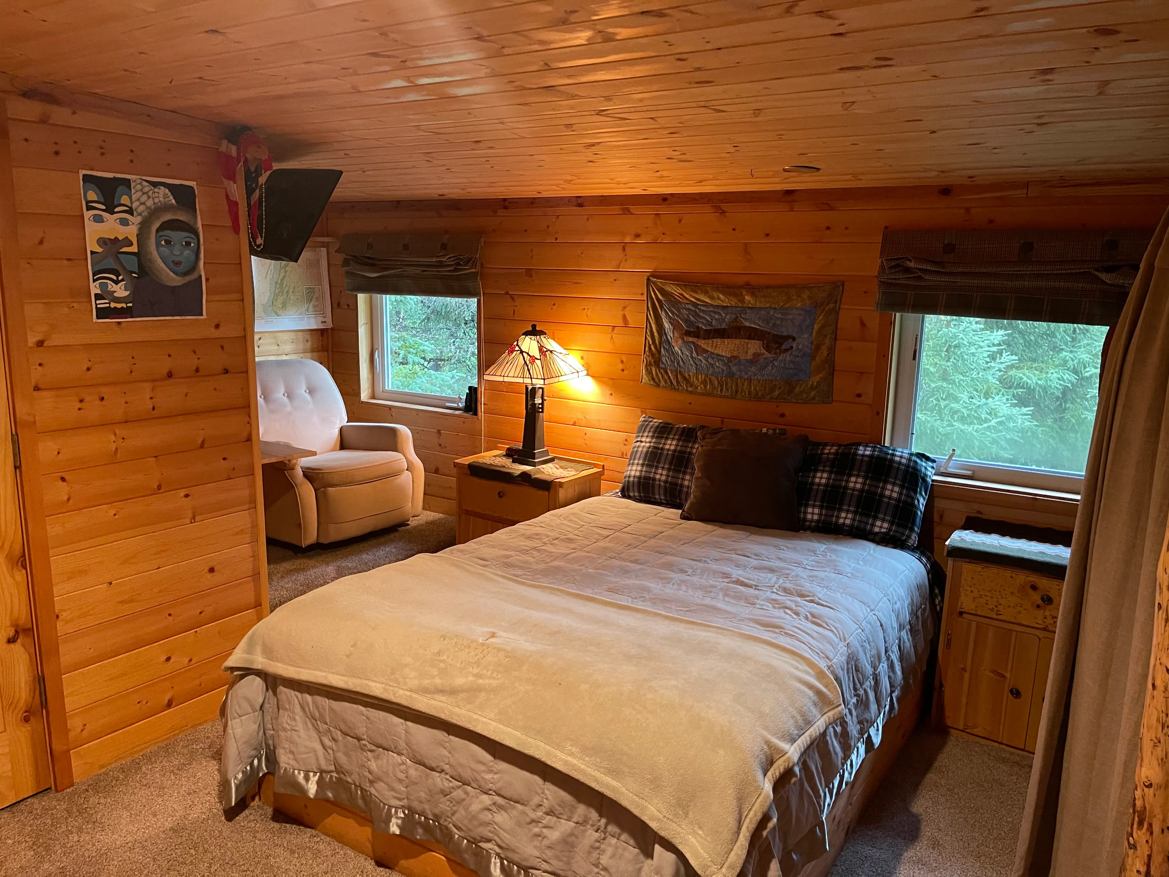A pine-walled room with the beds made up