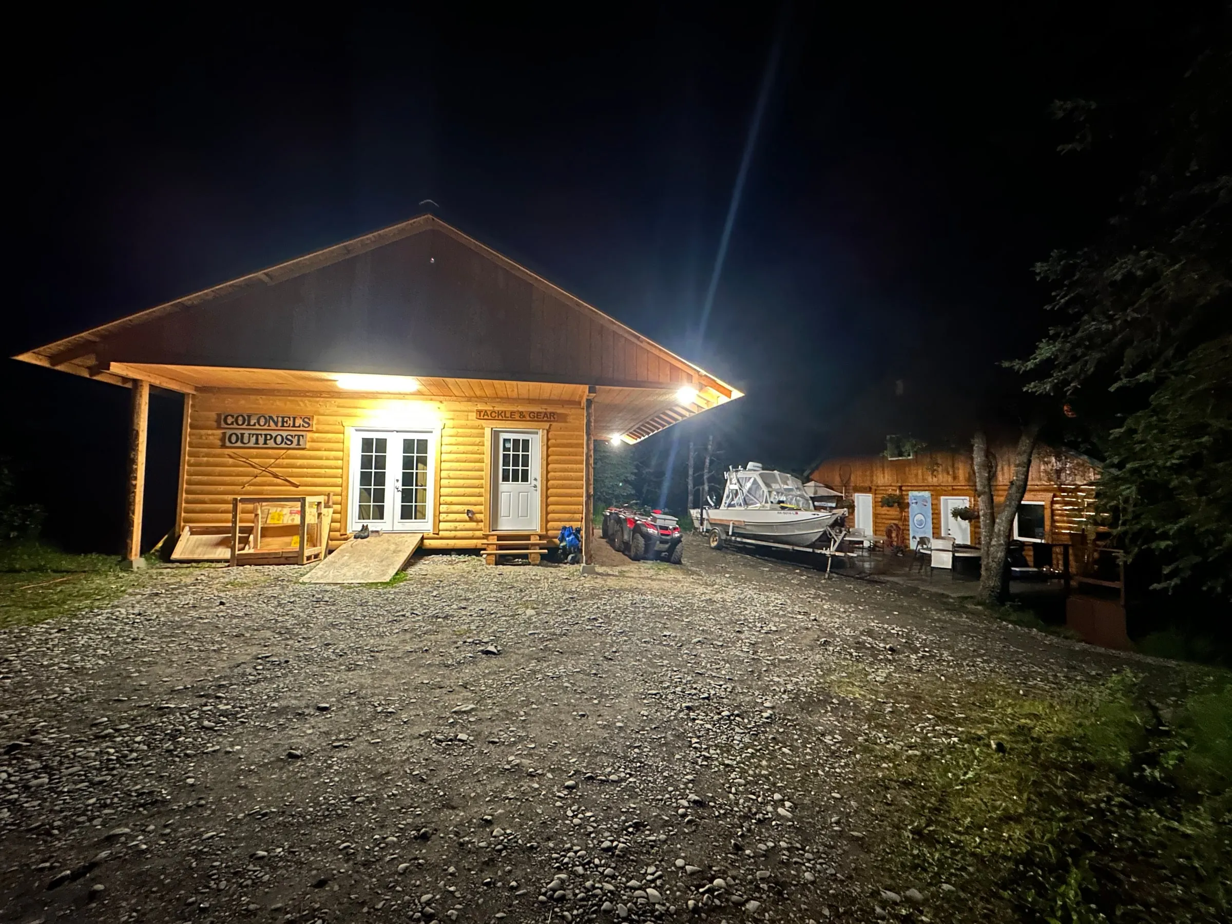 The Outpost glowing against the dark treeline at dusk