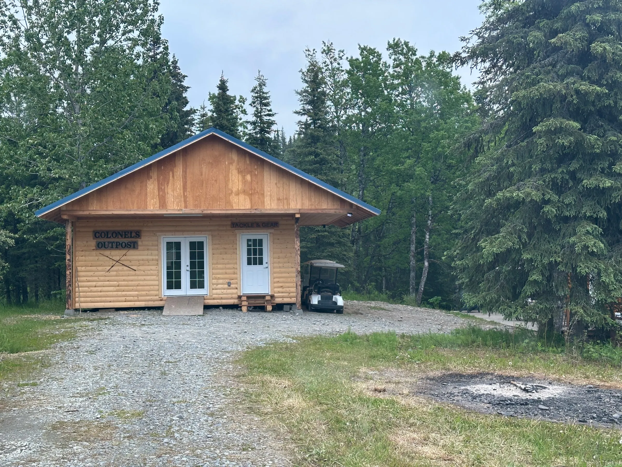The Outpost nestled into the spruce off the gravel