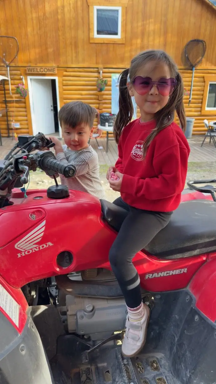 Kids climbing onto the ATV, excited