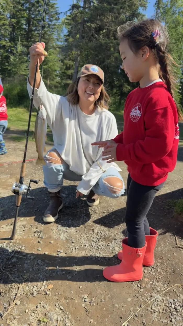 A young angler grinning, pole in hand