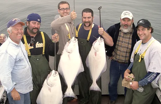 Group of anglers displaying their salmon catch on a boat