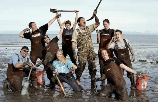 Crew and guests posing together on a fishing vessel