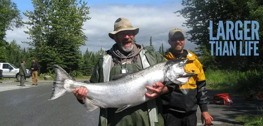 Angler holding up a large halibut on the water.