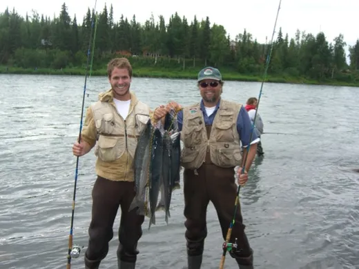 Anglers wading and fishing together in an Alaska river.