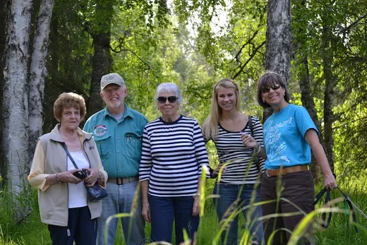 Family group posing outdoors with large white halibut.