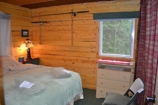 Cozy cabin bedroom with wood-paneled walls and twin beds.