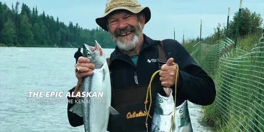 Happy angler holding a trophy-sized salmon with a big grin.