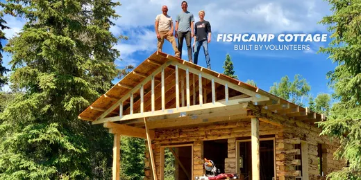 Framed cabin structure under construction in a wooded setting