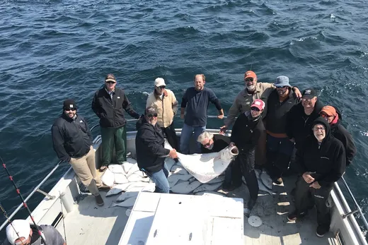 Group of guests on a fishing boat heading out on the water.