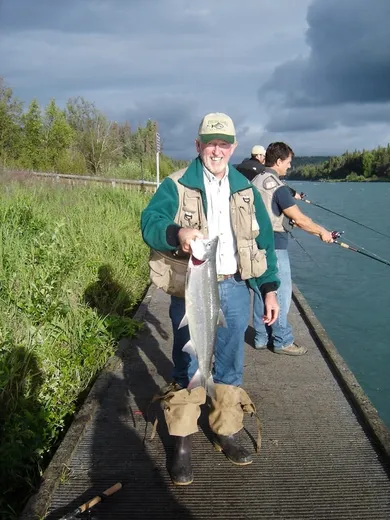 Guests on the dock with fishing rods and a catch.