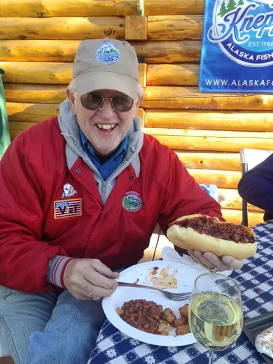 Guest smiling at the table with a plate of fresh fish.