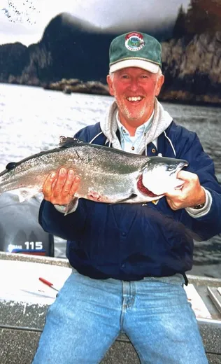 Angler proudly holds up a large salmon on the river.