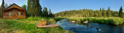 Lodge cabin visible across the river flats