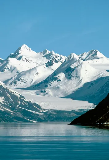 Dramatic Alaskan mountain peaks under blue sky