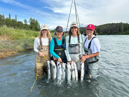Happy group wading in the river with a salmon catch