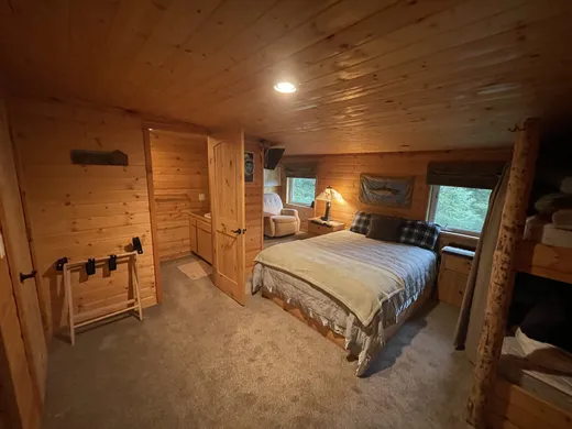 Cabin room interior with corner window and natural light.
