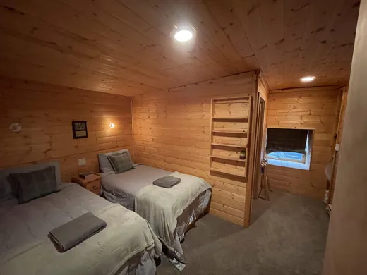 Simple cabin room with a single bed and curtained window.