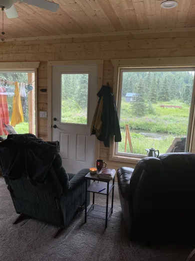 Warm cabin interior with couch and rustic wood décor.