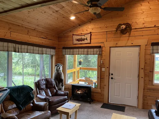 Cabin interior with desk, chair, and large window.